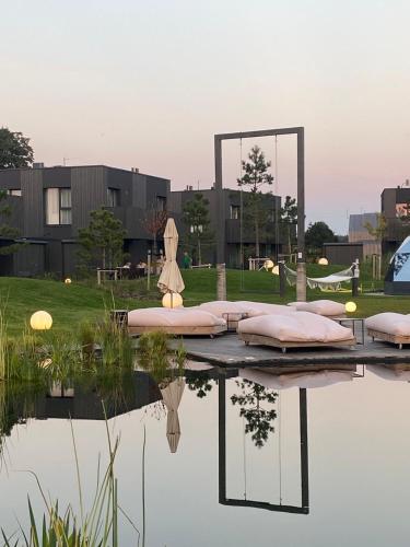 a view of a pond with pink pillows and a mirror at GOLD apartment / Mano jūra 3 in Kunigiškiai