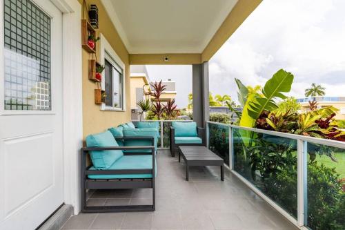 a balcony with blue chairs and a view of the ocean at serendipity on the beach Ocho Rios in Saint Annʼs Bay
