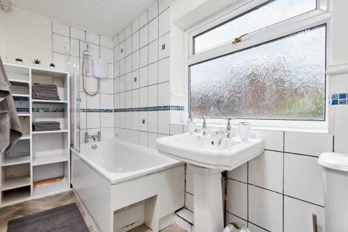 un bagno bianco con lavandino e finestra di Comfortable house by the coast a Redcar