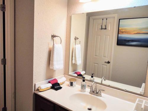 uma casa de banho com um lavatório e um espelho grande em Lakefront Oasis em Hot Springs