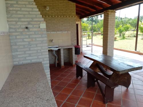 a patio with a wooden table and a kitchen at La herencia in Caacupé