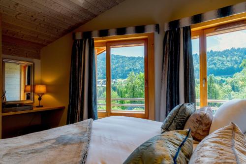 een slaapkamer met een bed en een groot raam bij Luxury Chalet Espoir in Montriond