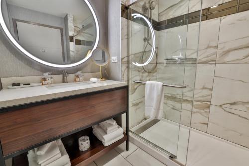 y baño con ducha, lavabo y espejo. en Wind Creek Bethlehem Casino & Resort, en Bethlehem