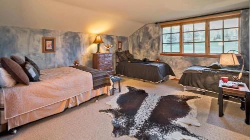 1 Schlafzimmer mit 2 Betten, einem Tisch und einem Fenster in der Unterkunft Chalet Fairway in Beaver Creek