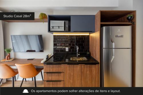 a kitchen with a stainless steel refrigerator and a microwave at House of Charlie Paraiso in Sao Paulo