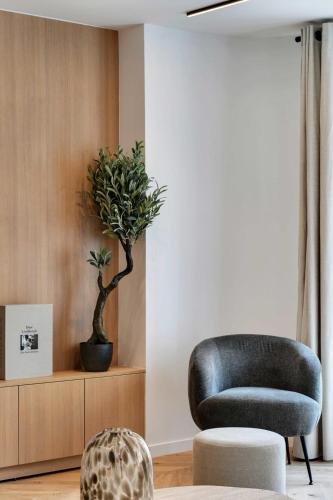 un salon avec une chaise et une plante dans l'établissement Incredible flat - 4 BR-10P - Matignon - Champs Elysées, à Paris