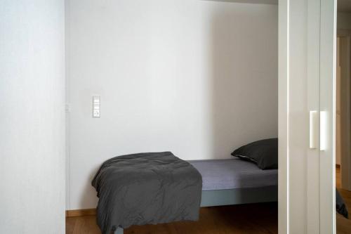 a bedroom with a bed in a white room at Über den Dächern der Innenstadt Ravensburgs in Ravensburg