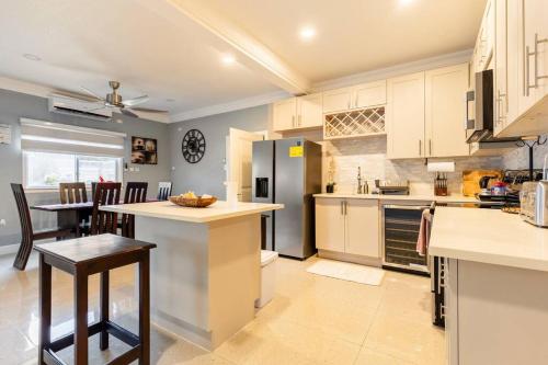 a kitchen with white cabinets and a counter top at serendipity on the beach Ocho Rios in Saint Annʼs Bay