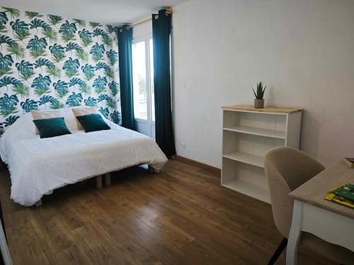 a bedroom with a bed and a desk and a window at Appart proche plage Calais in Calais
