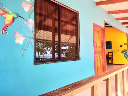 um quarto com um mural de pássaros na parede em Tortuguero Adventures Beach House em Tortuguero