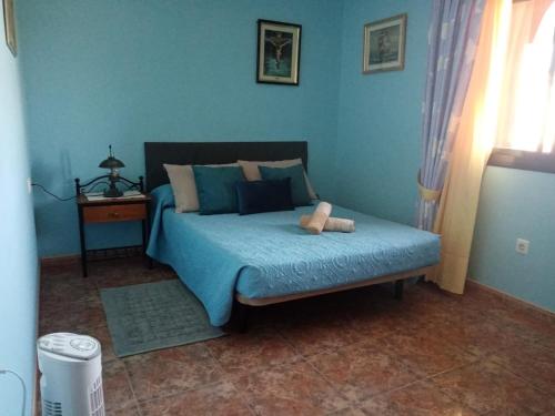 Un dormitorio azul con una cama con un osito de peluche. en LAMI, en Las Playitas
