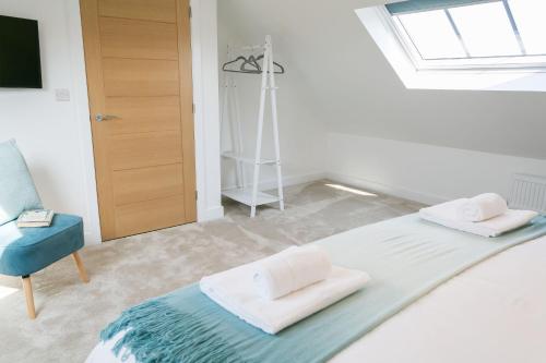 1 dormitorio con cama, ventana y silla en Bwncath en Llanrhwydrys