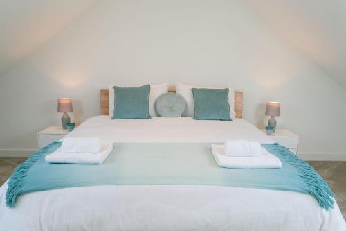 1 cama blanca grande con 2 almohadas en Bwncath en Llanrhwydrys