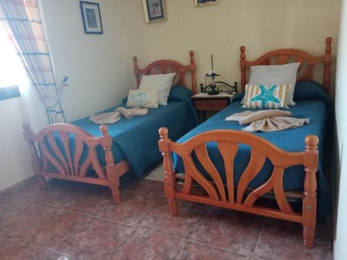 1 dormitorio con 2 camas y sábanas azules en LAMI en Las Playas