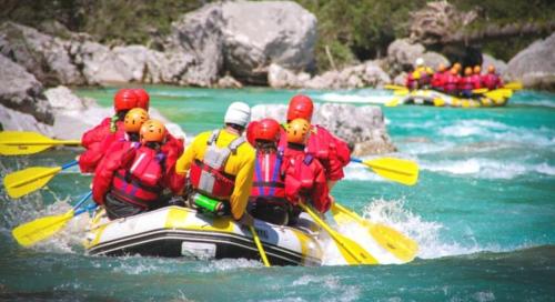 a group of people in a raft on a river at Residence Soča in Soča