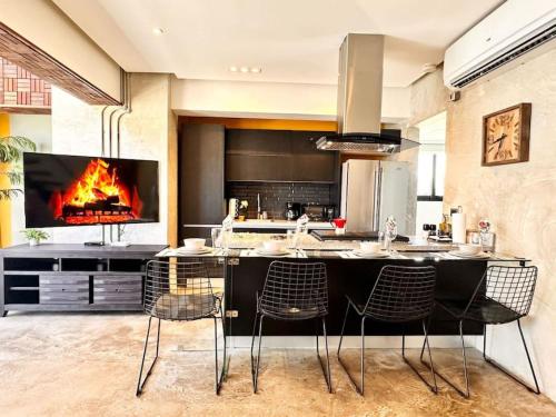 a kitchen with a bar with chairs and a fireplace at New Loft Apt Full AC King Bed in Santo Domingo