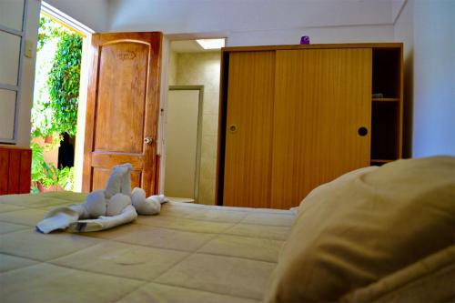 a stuffed animal laying on top of a bed at Hostal Michel in Vicuña