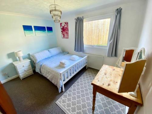 a small bedroom with a bed and a table at Seaview Bungalow, Thurlestone, Beaches Nearby in Thurlestone