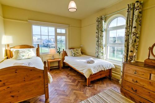 a bedroom with two beds and a window at Cable Cottage in Llanrhyddlad