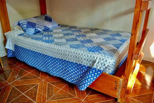 a small bed with a blue and white quilt on it at Hostal Michel in Vicuña