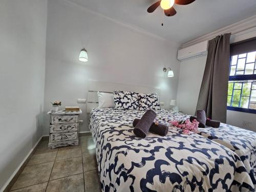 a bedroom with a bed with a blue and white comforter at JUMA HOLIDAYS in Puerto del Carmen