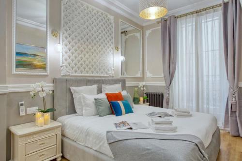 une chambre avec un grand lit avec un miroir dans l'établissement Charmant 160m² 6CH-Haussmannien Climatisé & Ascens, à Paris