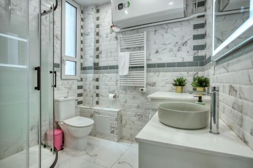 une salle de bain avec un lavabo, des toilettes et une douche dans l'établissement Charmant 160m² 6CH-Haussmannien Climatisé & Ascens, à Paris