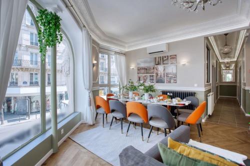 une salle à manger avec une table et des chaises dans l'établissement Charmant 160m² 6CH-Haussmannien Climatisé & Ascens, à Paris