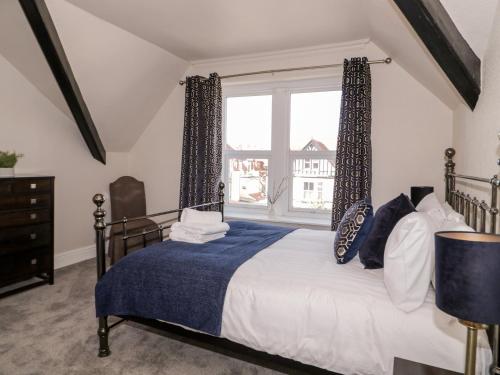a bedroom with a bed and a large window at The Keep in Llandudno