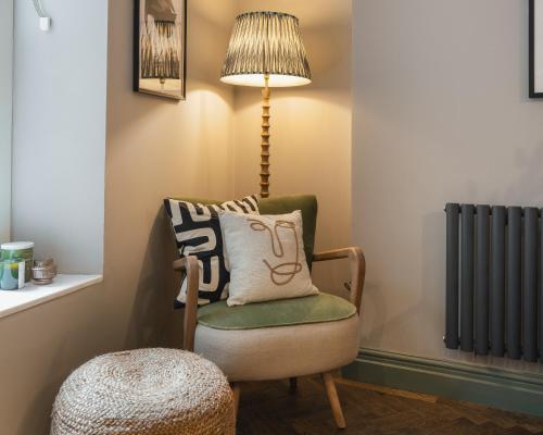 a chair with a pillow and a lamp in a room at The Cotham Arms Apartments in Bristol