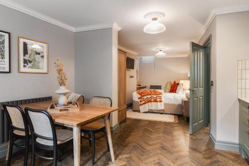 a room with a dining table and a bedroom at The Cotham Arms Apartments in Bristol
