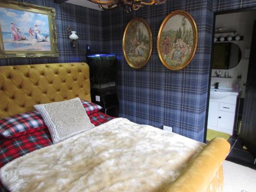 a bedroom with a bed and three pictures on the wall at Woodston Fishing Station in Saint Cyrus