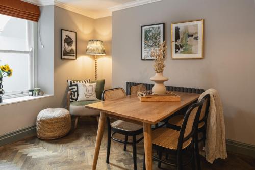 - une salle à manger avec une table et des chaises en bois dans l'établissement The Cotham Arms Apartments, à Bristol