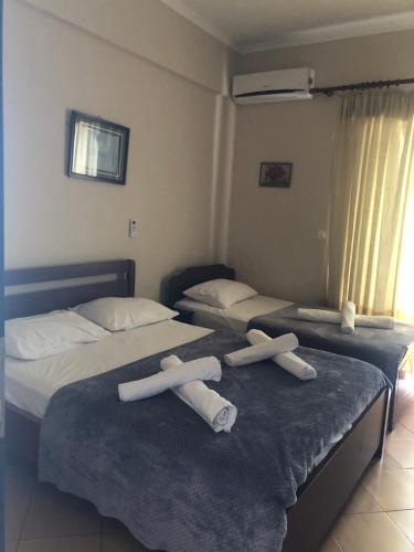 two beds in a hotel room with towels on them at Studio Apartments Rizarjo in Ksamil