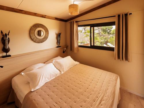 Schlafzimmer mit einem Bett und einem Fenster in der Unterkunft Les Gîtes du Bioparc 
