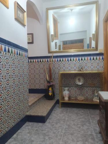 uma casa de banho com um espelho e uma parede em azulejo em Casa turística en pleno centro de Úbeda em Úbeda