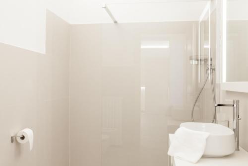 a white bathroom with a toilet and a shower at Palazzo dei Ciompi Suites in Florence