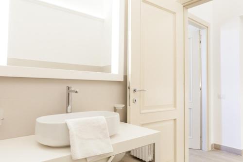 a white bathroom with a sink and a mirror at Palazzo dei Ciompi Suites in Florence