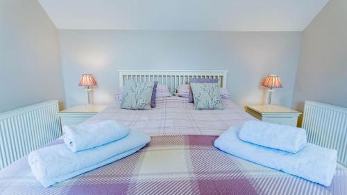 a bedroom with a large bed with blue pillows at Efail Penrhyn in Llanfachraeth