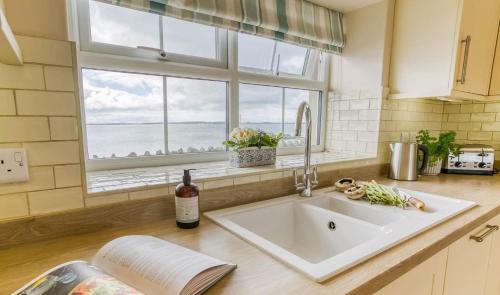 a kitchen counter with a sink and a window at Efail Penrhyn in Llanfachraeth