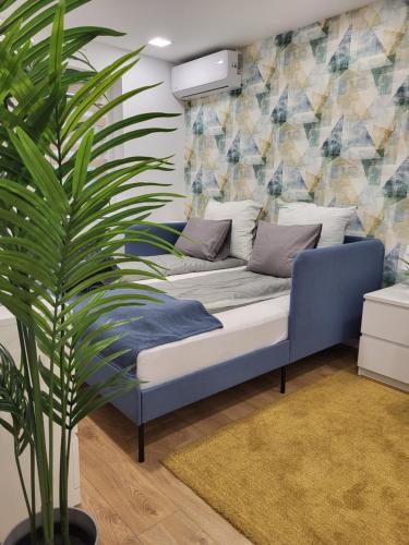 un sofá en una sala de estar con una planta en Kossuth 10, en Dunaújváros