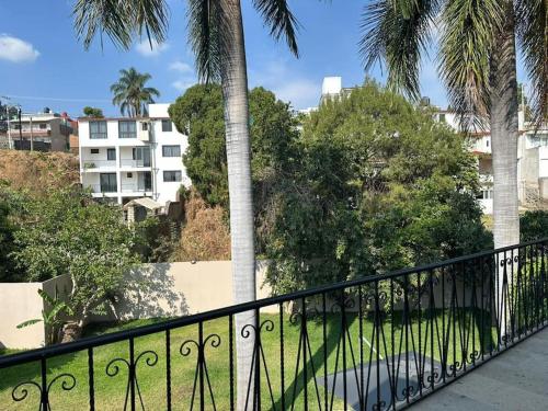 d'un balcon avec une balustrade noire et des palmiers. dans l'établissement Casa privada en Villa Bricia, à Cuernavaca