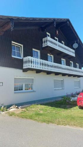 a white house with a white balcony on it at Ferienwohnung Eleni in Mauth