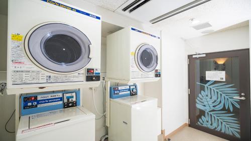 a laundry room with a washing machine and a washer at Nishitetsu Resort Inn Naha in Naha