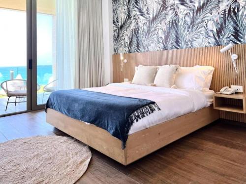a bedroom with a large bed with a blue blanket on it at Indigo Jungle Beachfront Exotic Room in Batroun 