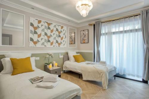 une chambre avec deux lits et un lustre dans l'établissement Apart 110m2- 3CH-CLIM-Très spacieux, à Paris