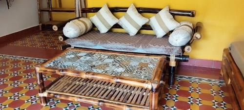 a couch with pillows on it in a room at Mithila Eco Stay - Explore chettinad in Mithilaipatti