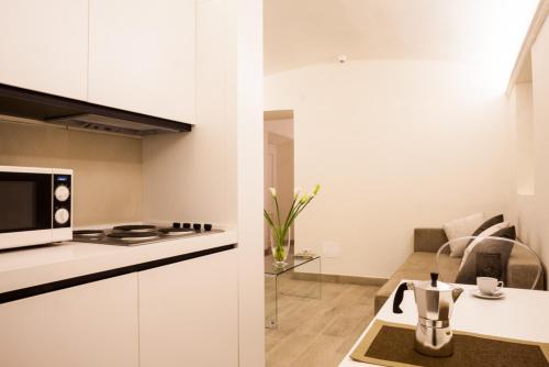 a kitchen and a living room with a stove and a microwave at Palazzo dei Ciompi Suites in Florence