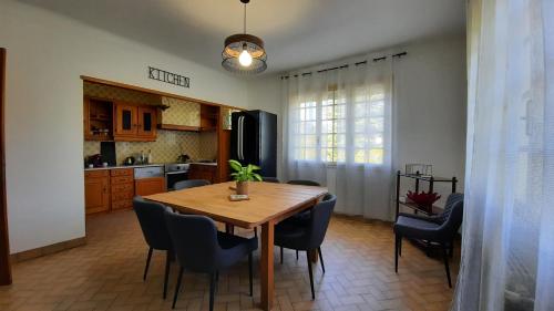 una cucina e una sala da pranzo con tavolo e sedie in legno di La maison de Lili a Colayrac-Saint-Cirq
