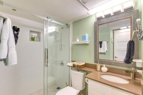 ein Badezimmer mit einem WC, einem Waschbecken und einem Spiegel in der Unterkunft Beachfront Galveston Condo with Pool and Ocean Views! in Galveston